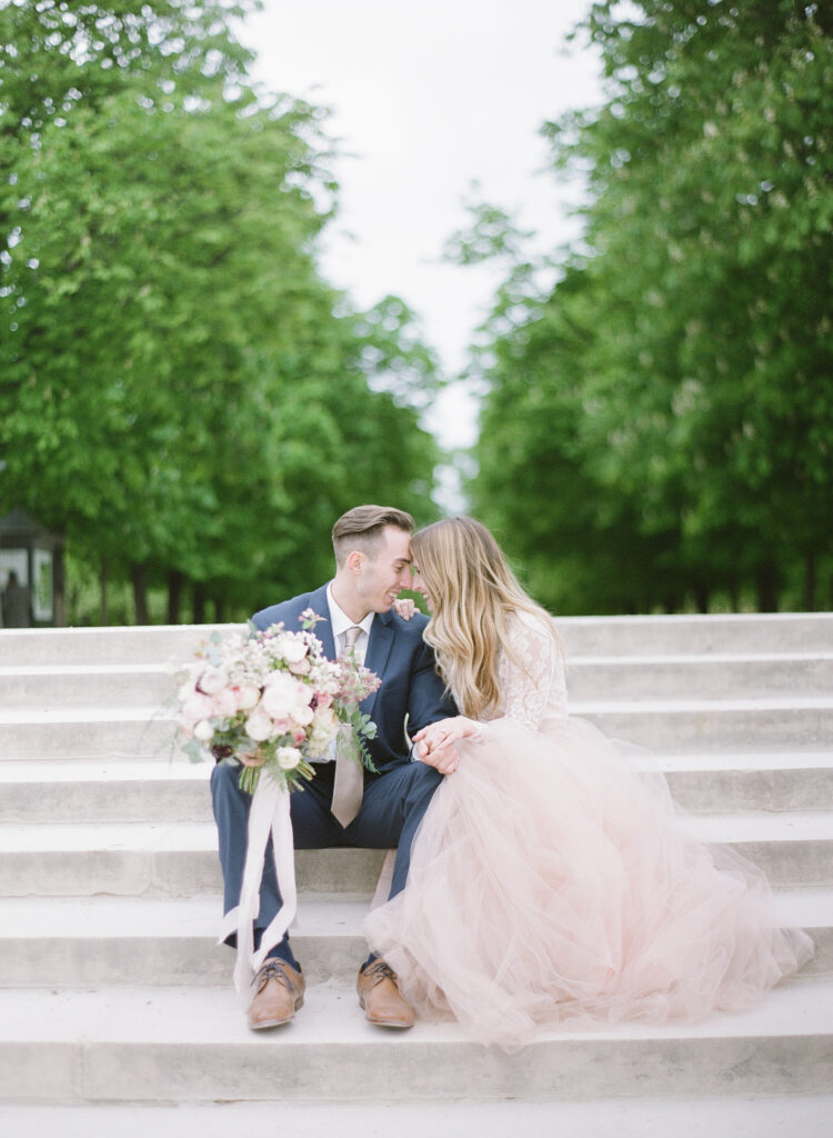 bride and groom look at each other and sitting on steps 