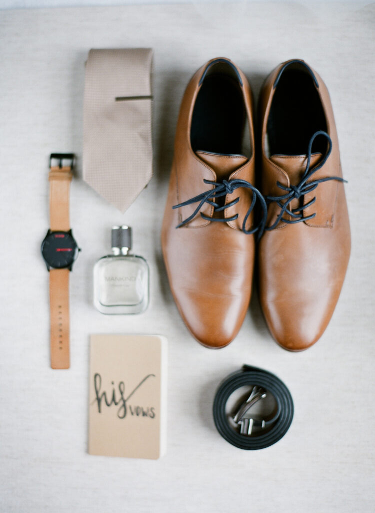 grooms details including lught brown Cole Haan dress shoes, blush tie, vow book, cologne and watch 