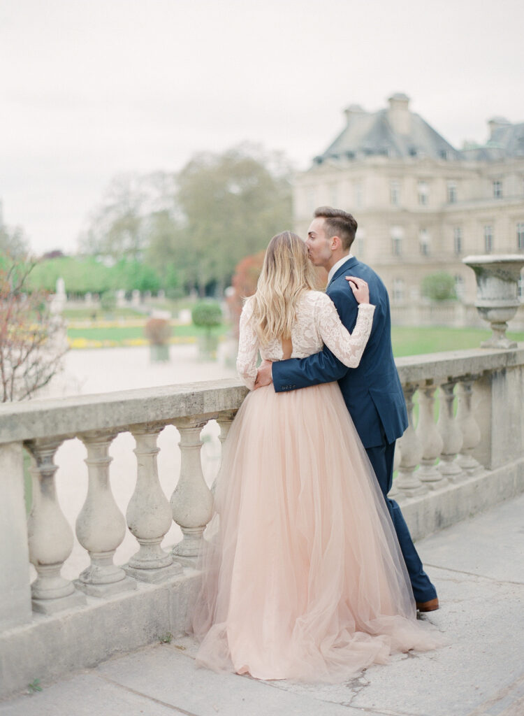 bride and groom leaning on stone railing 