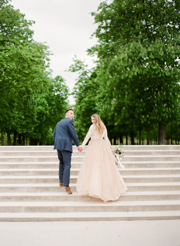 bride and groom walking steps in jardin de luxembourg 