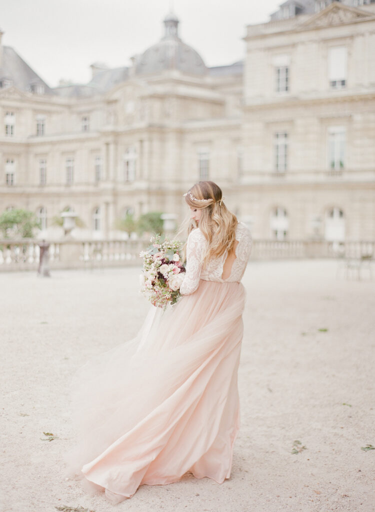 bride looking back and walking in front of the palace at jardin de luxembourg 