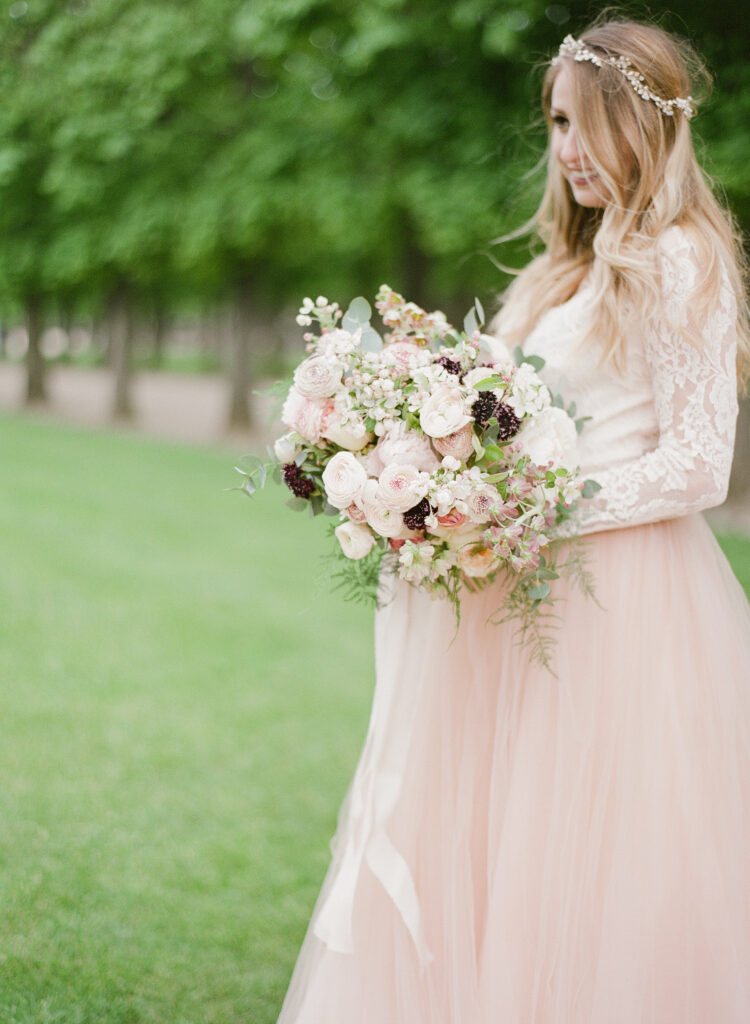 bride wearing lace blush gown carrying a picturesque bouquet 