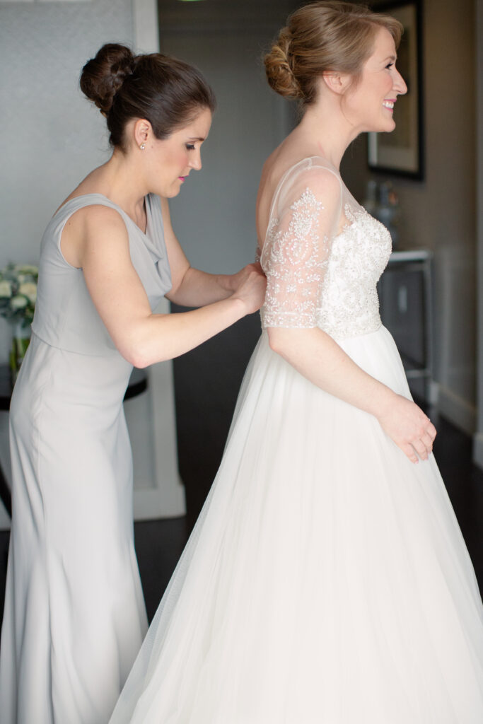 sister zipping brides dress 