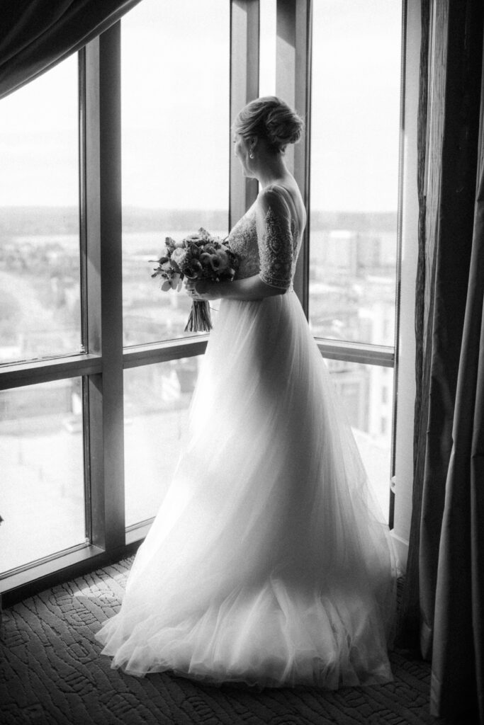 black and white portrait of bride looking out the window 