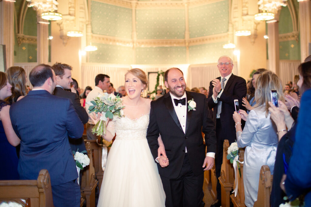 bride and groom walking out of church 