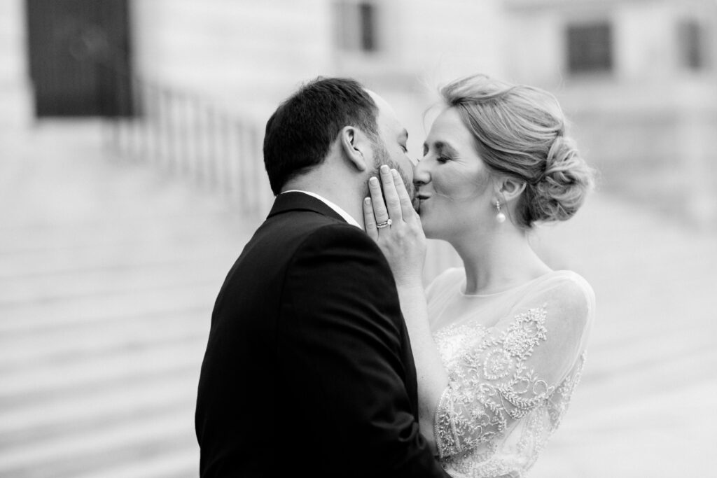 black and white of bride kissing