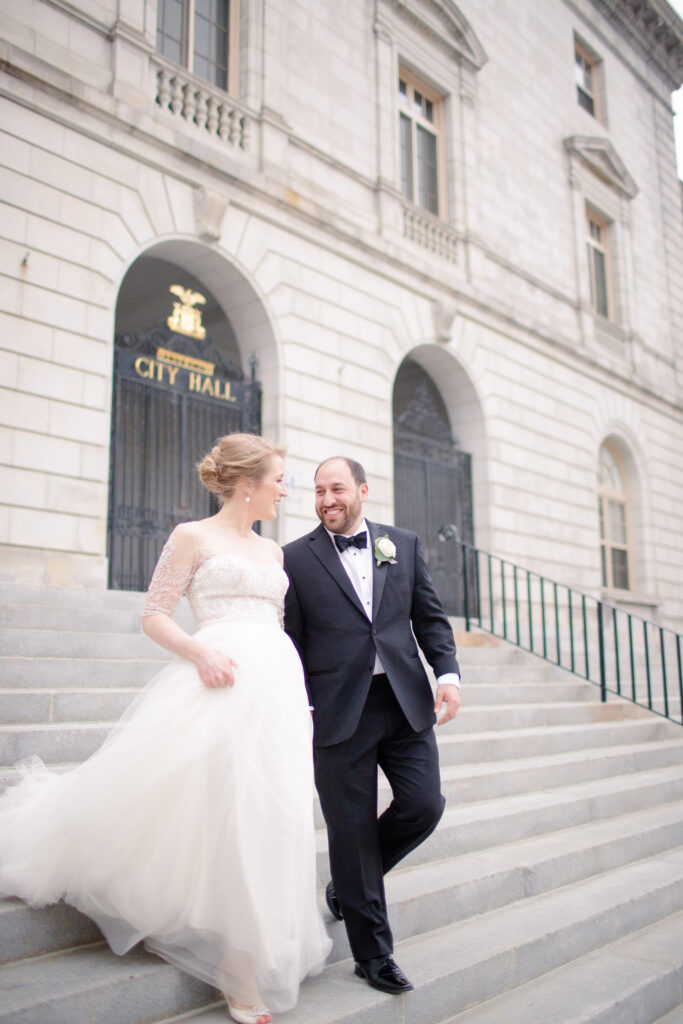 bride and groom walking out of city hall