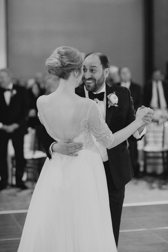 black and white of bride and groom dancing in ballroom 