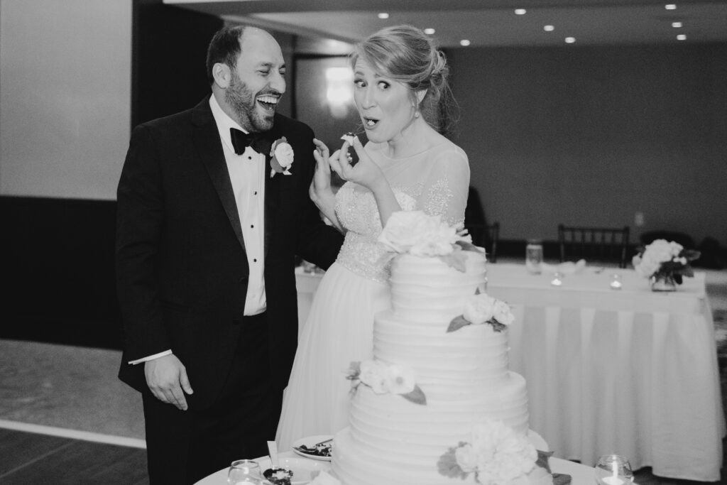 bride and groom making funny face while cutting cake